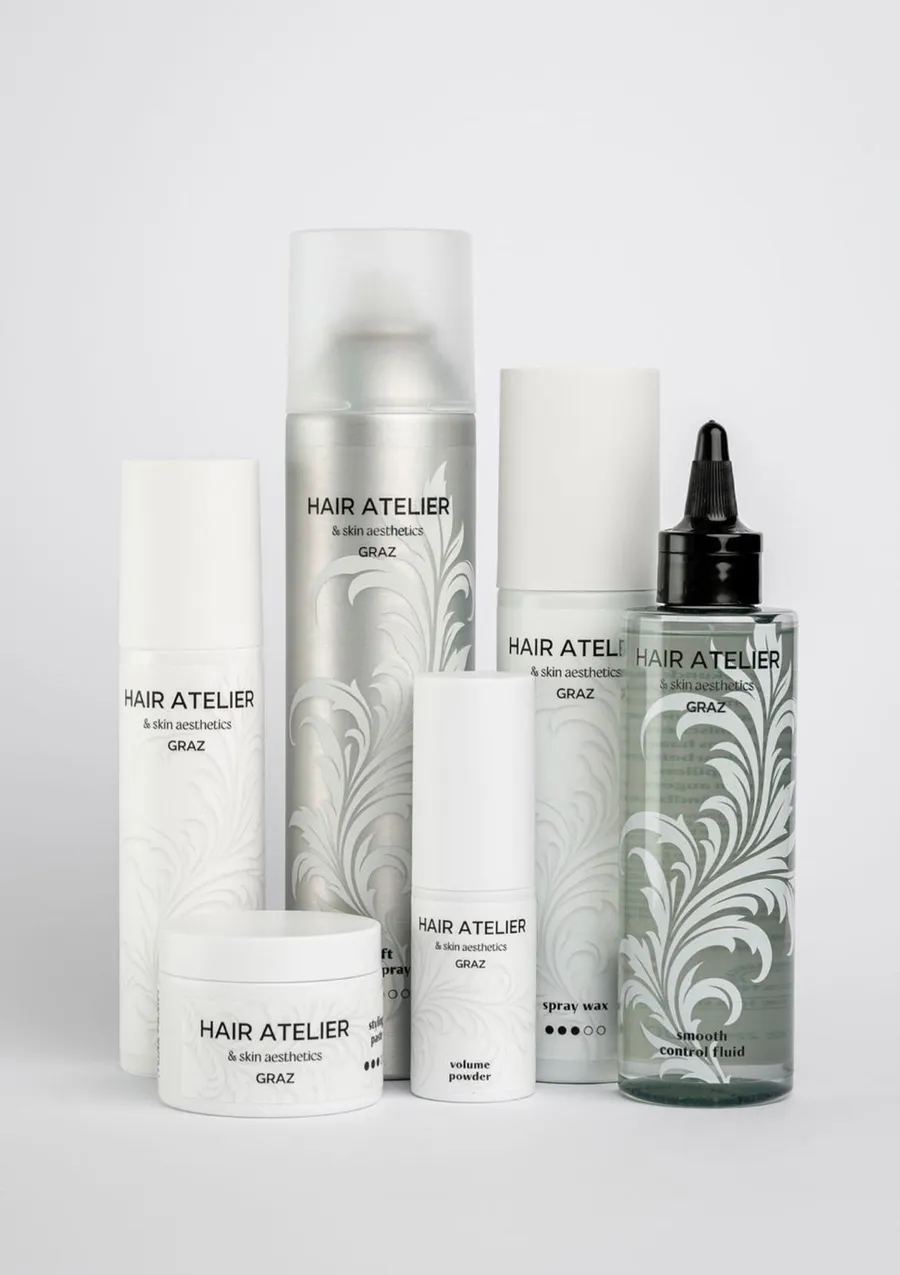Haarpflege- und Stylingprodukte der eigenen Linie des Hair Atelier Graz, darunter Spray Wax, Volume Powder und Smooth Control Fluid